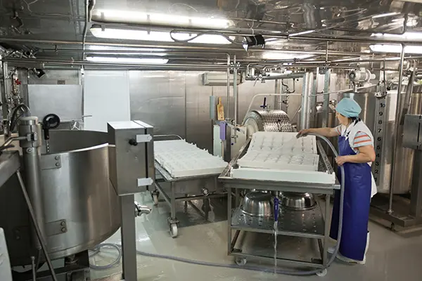 Worker operating industrial kitchen equipment, highlighting the need for commercial appliance repair and maintenance services.