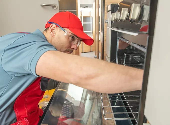 Technician performing commercial oven repair as part of San Jose HVAC Guys' appliance repair services.